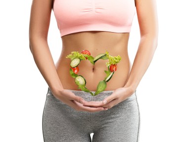 Fit, young woman holding a heart made out of vegetables